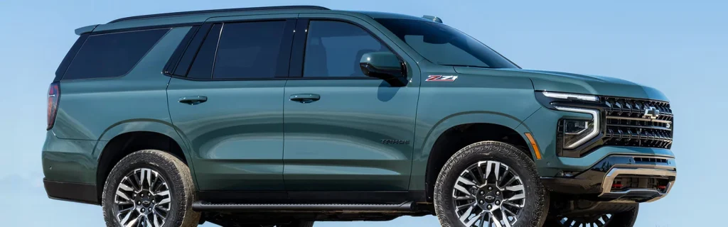 The image shows a green Chevrolet Tahoe Z71 SUV parked against a clear blue sky.